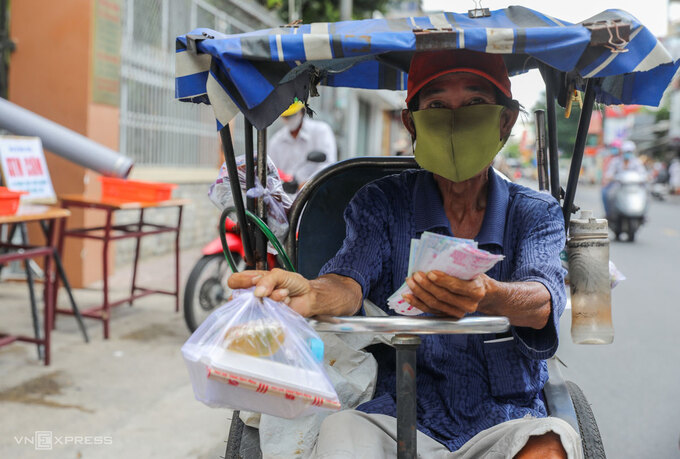 Ông Thành, bán vé số ở TP HCM nhận cơm 0 đồng trong những ngày thành phố giãn cách chống dịch, tháng 6/2021. Ảnh: Quỳnh Trần